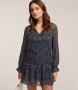 Vestido corto azul marino con estampado de flores blancas y rojas, escote en V, mangas largas con puños elásticos y falda con volantes. Incluye cinturón negro con hebilla dorada.