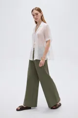 Blusa blanca de lyocell con cuello solapa, mangas cortas y cierre frontal mediante cordones para anudar.