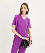 Blusa color violeta con cuello en V, mangas cortas con volados y textura airflow.