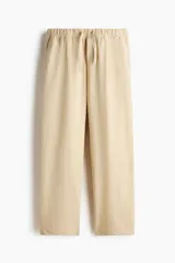 Pantalón en punto de mezcla de algodón, color beige, de corte regular y piernas rectas. Cuenta con cintura elástica con cordón ajustable, bolsillos laterales al bies y bolsillos traseros de parche.