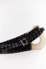 Cinto faja de cuero con estampado de vaca en blanco y negro, con hebilla metálica rectangular.