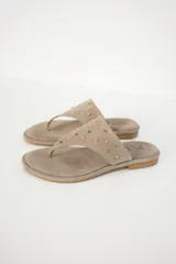 Sandalias de cuero color beige con apliques metálicos redondos.