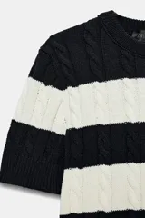 Sweater de punto con diseño de rayas horizontales anchas en color negro y blanco, cuello redondo y manga corta.