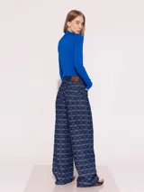 Pantalón de jean azul con estampado de besos en blanco, de corte ancho y tiro medio.