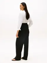 Pantalón de traje de corte recto, confeccionado en una mezcla de lino y lyocell. Presenta un diseño con cierre de cremallera oculta, gancho, cintura elástica en la parte trasera y bolsillos traseros de parche.