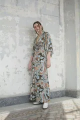 Kimono largo con estampado paisley en tonos marrones, celestes y naranjas. Tiene mangas 3/4 amplias y corte cruzado con lazo en la cintura.