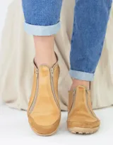 Zapatito marrón de cuero con puntera de gamuza, cierre frontal con cremallera y tirador trasero.