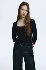 Remera entallada de punto suave, color negro, con escote cuadrado y mangas largas.