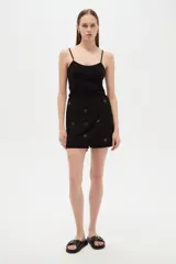 Short pollera negro de algodón y viscosa, de corte holgado, con detalles bordados en el frente.