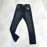 Pantalón jean negro skinny con roturas en las rodillas y muslos.