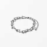 Pulsera plateada con eslabones rectangulares unidos por pequeñas esferas. Cierre de mosquetón con cadena de extensión.