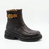 Bota de caña baja de cuero marrón oscuro texturizado, con suela track negra de goma y detalle de tira de gamuza tostada con hebilla metálica en el lateral.