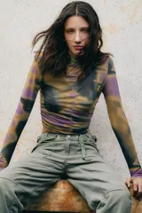 Top de microtul con cuello alto y cierre en la espalda. Cuenta con frunces en el pecho y enganche para el pulgar.