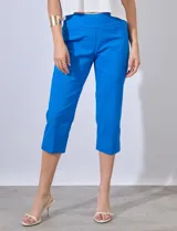 Pantalón capri de gabardina elastizada color celeste, con bolsillos simulados delanteros y bolsillos aplicados traseros. Tiene pretina ancha, corte recto y detalle calado en el ruedo.