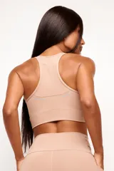 Top deportivo de alto rendimiento con diseño de espalda nadador, confeccionado en tejido técnico con protección UV50+. Presenta un bolsillo interno en el forro frontal y detalles reflectivos.