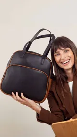 Mochila color bordó con doble asa superior, correas traseras regulables y bolsillo frontal con cierre. Se puede usar como mochila o como cartera.