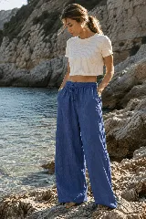 Pantalón ancho de lino color azul, de corte relajado con cintura elástica con cordón ajustable y bolsillos laterales.