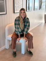 Camisa de color marrón oscuro con cuello clásico y mangas abullonadas con puños elásticos. Presenta un corte holgado y cierre frontal con botones.