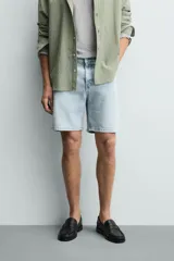 Bermuda de jean con corte regular fit, confeccionada en denim de algodón con elasticidad. Presenta diseño de cinco bolsillos, efecto lavado y cierre frontal con cremallera y botón.