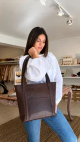 Blusa blanca de manga larga con volados frontales y cuello redondo, confeccionada en tejido texturizado con puños elásticos.