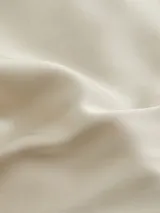 Camisa color crema de satén con cuello italiano, cierre frontal con botones y mangas largas.