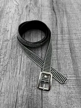 Cinto negro con apliques de strass plateados y hebilla metálica plateada con detalle de strass.