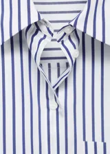Camisa de corte recto y diseño crop, con estampado de rayas verticales en azul y blanco. Presenta cuello camisero, cierre frontal con botones y un bolsillo en el pecho.