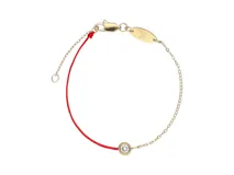 Pulsera de hilo rojo con dije de oro y circonita, con cadena de oro y cierre de mosquetón.