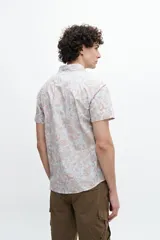 Camisa de manga corta confeccionada en tela 100% algodón con estampado de cachemir en tonos naranja y celeste. Tiene un bolsillo en el pecho y botones personalizados.