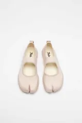 Zapatilla tipo Mary Jane color beige, con capellada tejida y suela gruesa.