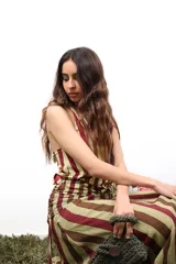 Falda larga de microtul elástico con estampado de rayas verticales en tonos verde claro, marrón y bordó. Presenta fruncido en la cadera.