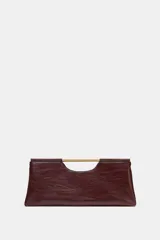 Bolso de mano de diseño estructurado en color bordó, con asa rígida dorada integrada en la parte superior y cierre magnético.