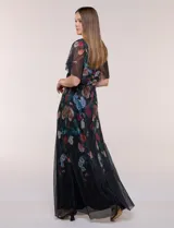 Vestido largo plisado con estampado floral, escote en V cruzado, mangas cortas fluidas y falda maxi con movimiento.