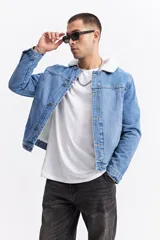 Campera de jean con interior de corderito, cuello clásico y cierre frontal con botones metálicos. Presenta un diseño de denim azul con costuras reforzadas y bolsillos laterales.