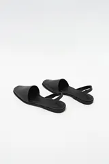 Zapato destalonado de cuero color negro, con punta cuadrada y diseño minimalista.