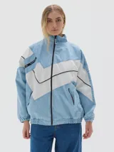 Campera de jean estilo deportivo con cierre frontal, cuello alto y diseño de paneles en forma de V en color blanco. Presenta corte oversized, puños y cintura elásticos, y bolsillos frontales con cierre.