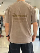 Remera oversize gris con efecto acid wash, de mangas cortas y cuello redondo, con estampado tipográfico blanco en la espalda.