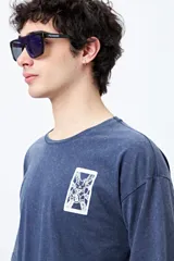 Remera negra de corte amplio con mangas cortas y cuello redondo. Presenta un pequeño estampado rectangular en el pecho y un estampado grande en la espalda con motivos japoneses.