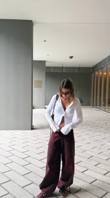 Pantalón de jean negro de tiro bajo con corte recto y ajuste mediante cordones en la botamanga, permitiendo un estilo tipo balloon.