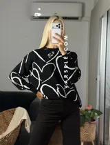 Sweater de tejido de punto con diseño abstracto de líneas blancas sobre fondo de color sólido. Presenta un corte clásico y textura suave.