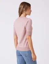 Buzo de tejido fino en color azul marino, con cuello redondo y mangas cortas con puños acanalados.