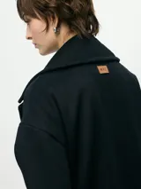 Tapado marrón de paño con doble botonadura, cuello solapa y bolsillos laterales.