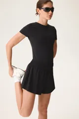 Pantalón corto deportivo negro de doble capa con cintura elástica fruncida y calzas ciclistas integradas.