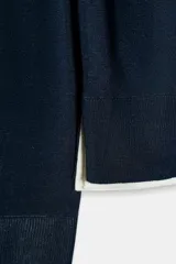 Jersey de punto verde militar con efecto doble, escote redondo y mangas largas con detalles en blanco en el cuello, puños y ruedo.