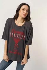 Remera negra de corte oversize con cuello redondo y mangas cortas holgadas. Cuenta con un estampado frontal en tonos rojos con la frase "Espresso Martini" y el dibujo de una copa de cóctel.