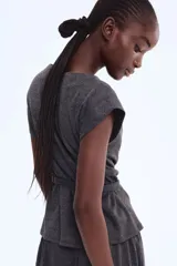 Top de manga corta color gris oscuro, con escote tipo capa o drapeado y un cinturón fino con hebilla metálica cuadrada que ajusta la cintura.