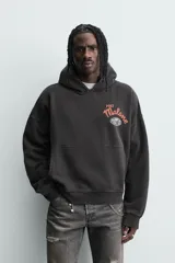 Sudadera con capucha de corte relajado y efecto lavado, confeccionada en mezcla de algodón con interior afelpado. Presenta manga larga, puños y bajo en rib, bolsillo frontal tipo canguro y estampado gráfico de Post Malone en el pecho.