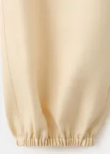 Pantalón largo color amarillo claro, de diseño balloon con cintura elástica de tiro medio y bajo con goma elástica.
