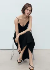 Vestido midi negro con tirantes finos, escote en V y detalle de lazo en el centro del busto. Diseño recto sin mangas y sin cierre.