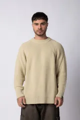 Sweater color crema de tejido de punto grueso con cuello redondo y corte holgado.